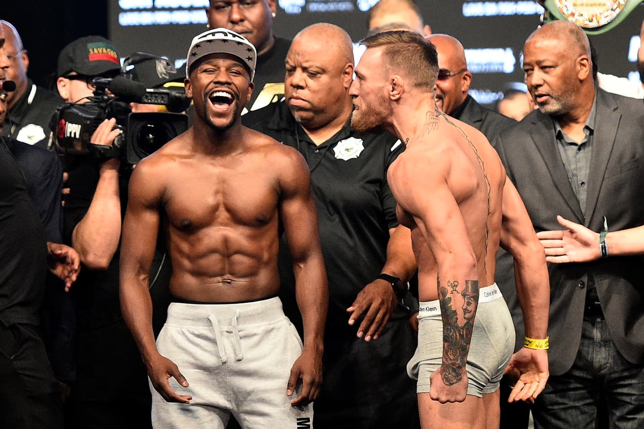 LAS VEGAS, NV - AUGUST 25: Boxer Floyd Mayweather Jr. (L) and UFC lightweight champion Conor McGregor face off during their official weigh-in at T-Mobile Arena on August 25, 2017 in Las Vegas, Nevada. The two will meet in a super welterweight boxing match at T-Mobile Arena on August 26. (Photo by Jeff Bottari/Zuffa LLC/Zuffa LLC via Getty Images)