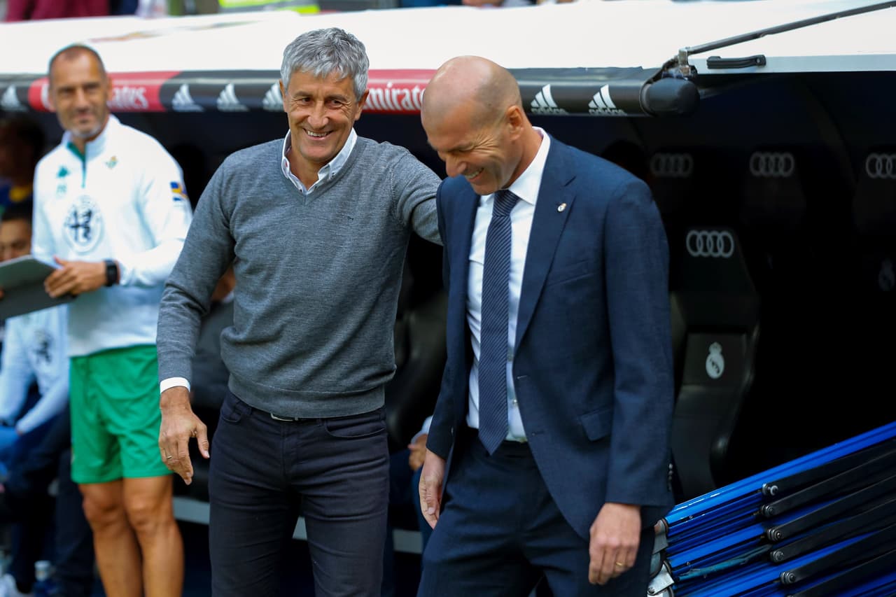 El entrenador del Real Madrid, el francés Zinedine Zidane (der.), y el del Betis, Quique Setién, tuvieron que conformarse con la igualdad al final del primer tiempo.