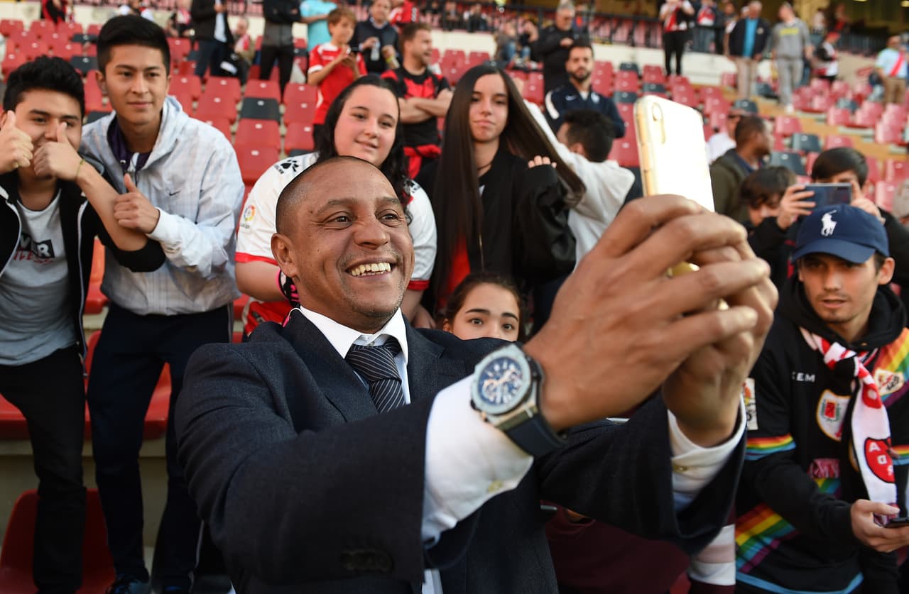 Roberto Carlos toma foto con fans.