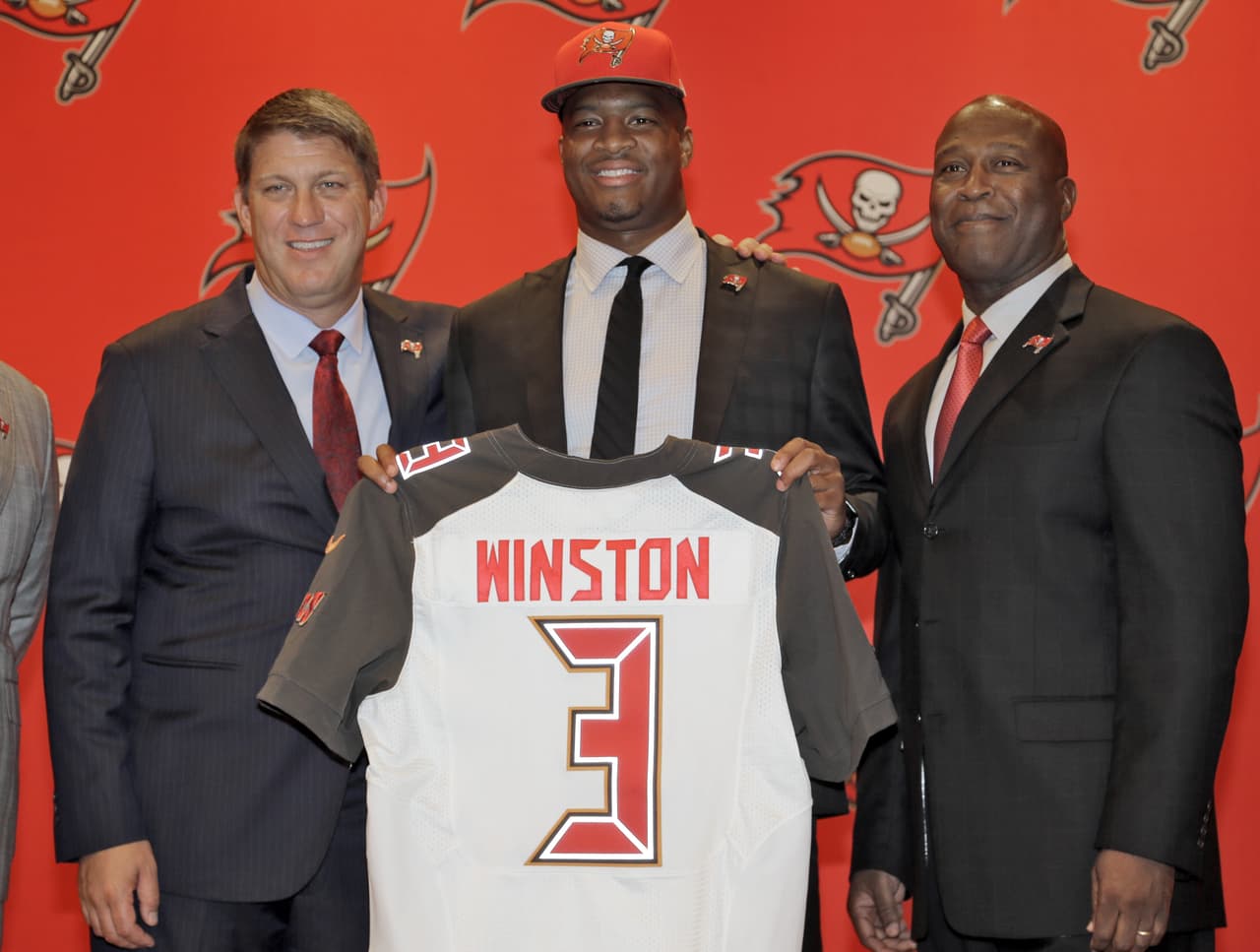 2015 — JAMEIS WINSTON
<b>Tampa Bay Buccaneers</b> | QB Florida State
<br>La primera selección global por los Tampa Bay Buccaneers, Jameis Winston (centro) sostiene su jersey con el gerente general Jason Licht, (izquierda) y el entrenador en jefe Lovie Smith (derecha) durante una rueda de prensa el viernes 1 de mayo de 2015, en Tampa, Winston. El ex mariscal de campo de la Florida, fue la primera selección general. (Foto de AP / Chris O'Meara)