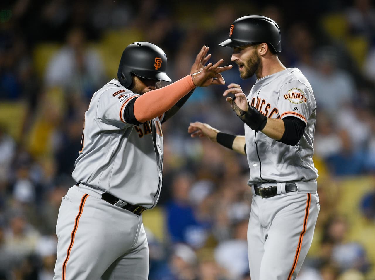Steve Duggar, derecha, celebra con Pablo Sandoval precisamente luego del doblete remolcador de Brandon Belt en la séptima entrada para dar ventaja decisiva de 4-2 a los San Francisco Giants
