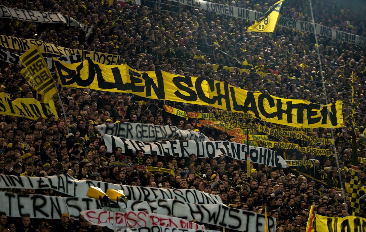 This picture taken on February 4, 2017 shows supporters of Dortmund displaying banners prior to the German First division Bundesliga football match between Borussia Dortmund and RB Leipzig, in Dortmund, western Germany. / AFP / SASCHA SCHUERMANN / RESTRICTIONS: DURING MATCH TIME: DFL RULES TO LIMIT THE ONLINE USAGE TO 15 PICTURES PER MATCH AND FORBID IMAGE SEQUENCES TO SIMULATE VIDEO. == RESTRICTED TO EDITORIAL USE == FOR FURTHER QUERIES PLEASE CONTACT DFL DIRECTLY AT + 49 69 650050 (Photo credit should read SASCHA SCHUERMANN/AFP/Getty Images)