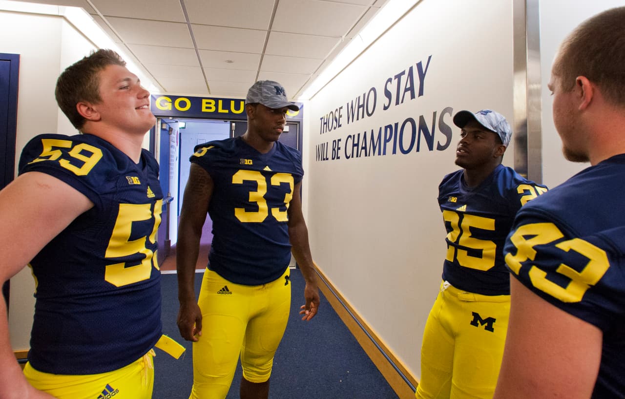 Michigan linebacker Jack Doyle (59), defensive end Taco Charlton (33), defensive back Dymonte Thomas (25), and long snapper Scott Sypniewski (43) chat inside the Michigan Stadium locker room, during the NCAA college football team's annual preseason media day, Sunday, Aug. 11, 2013, in Ann Arbor, Mich. (AP Photo/Tony Ding)
