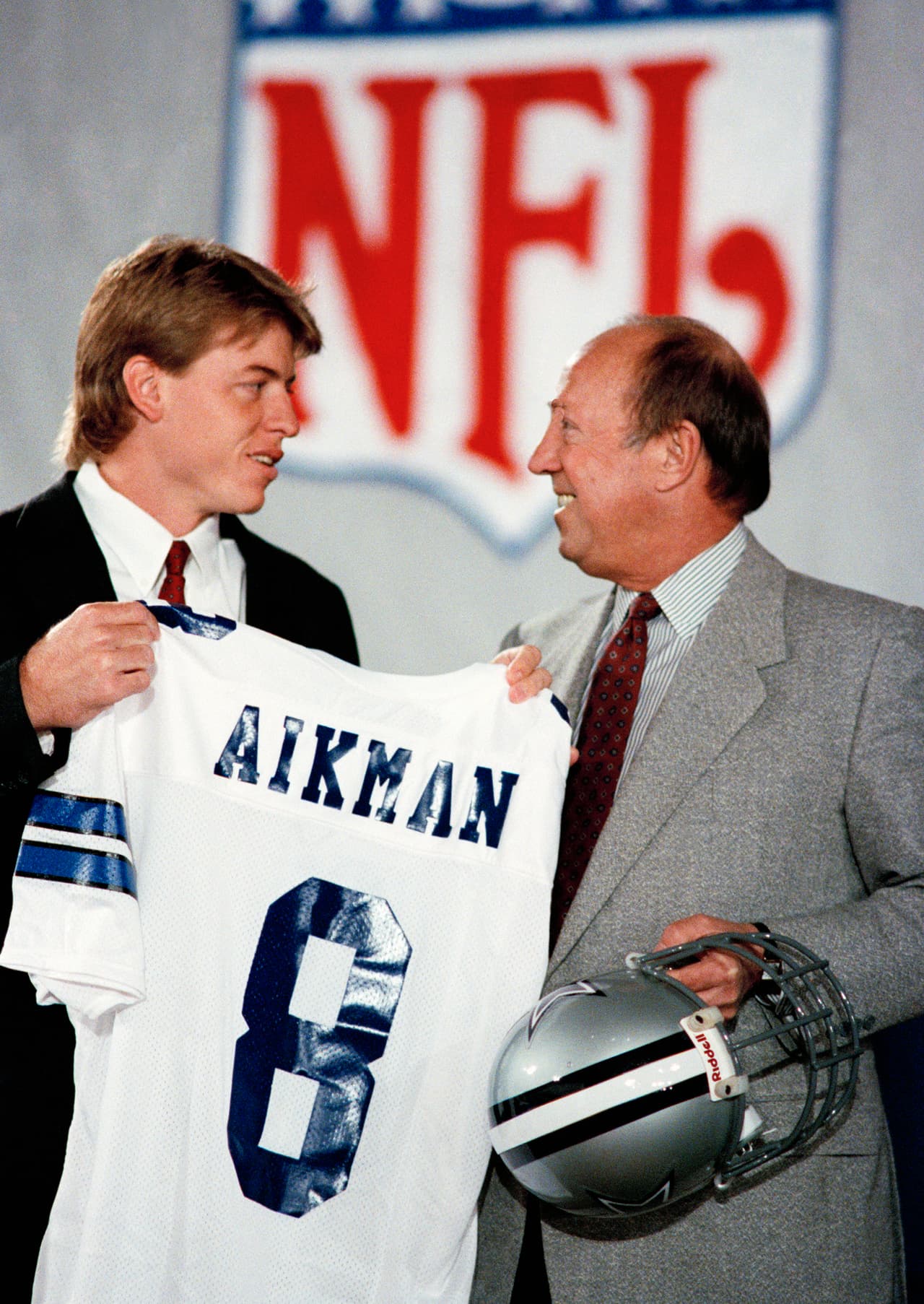 1989 — TROY AIKMAN
<b>Dallas Cowboys</b> | QB UCLA
<br>Pete Rozelle, comisionado de la NFL, comenzó la 54ª edición del draft de talento del fútbol colegial. En el 89’ vivió su último anunciando la selección del quarterback de UCLA, Troy Aikman, como la primera selección de los Dallas Cowboys el domingo 23 de abril de 1989 en Nueva York. Aikman ya había firmado un contrato de seis años y $ 11.2 millones con los Vaqueros. (AP Photo / Mark Lennihan)