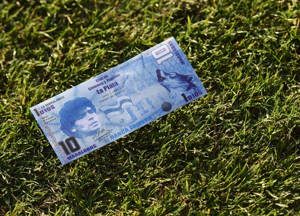 La réplica de un billete argentino con la cara de Maradona en él descansa en el terreno de juego.