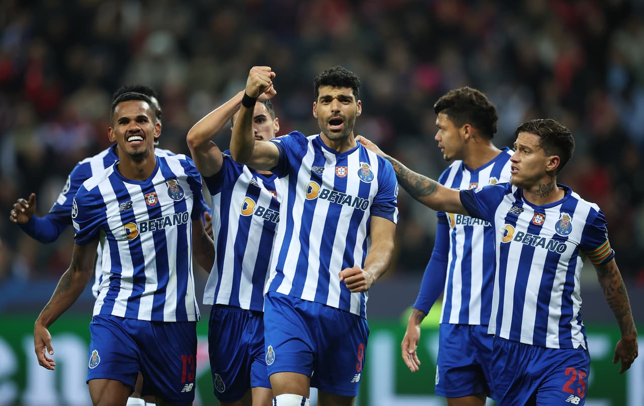 LEVERKUSEN, GERMANY - OCTOBER 12: Mehdi Taremi of FC Porto celebrates with teammates after scoring their team's third goal from the penalty spot during the UEFA Champions League group B match between Bayer 04 Leverkusen and FC Porto at BayArena on October 12, 2022 in Leverkusen, Germany. (Photo by Alex Grimm/Getty Images)