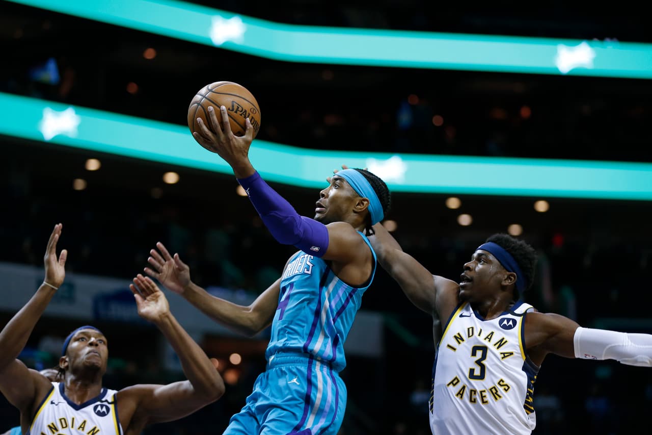 El guardia de los Hornets, Devonte' Graham, se encamina a la canasta bajo la mirada de Myles Turner y la impotencia de Aaron Holiday.
