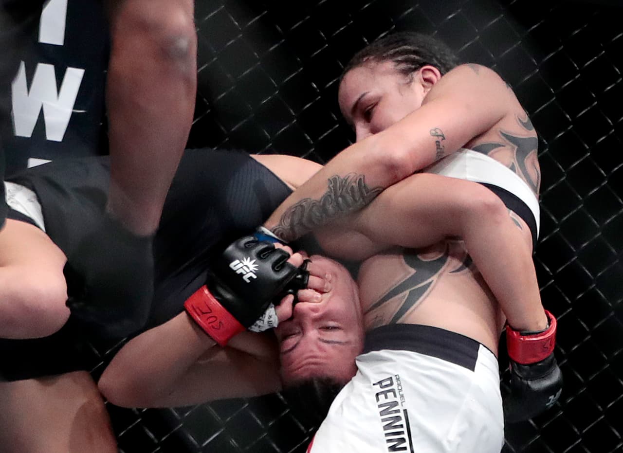 Raquel Pennington, right, grabs at Miesha Tate during a women's bantamweight mixed martial arts bout at UFC 205, Saturday, Nov. 12, 2016, at Madison Square Garden in New York. (AP Photo/Julio Cortez)