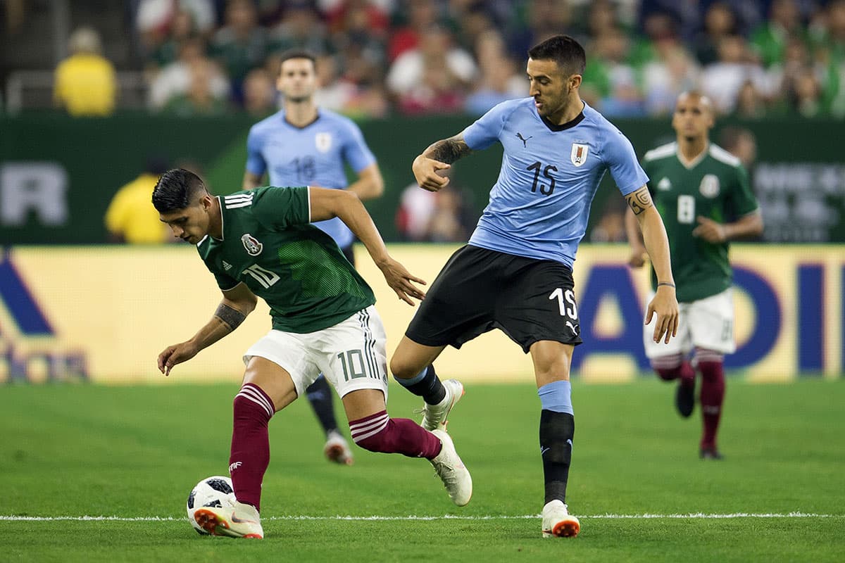 Alan Pulido (izquierda) recibe la marca de Matías Vecino (derecha) en los primeros minutos del juego.