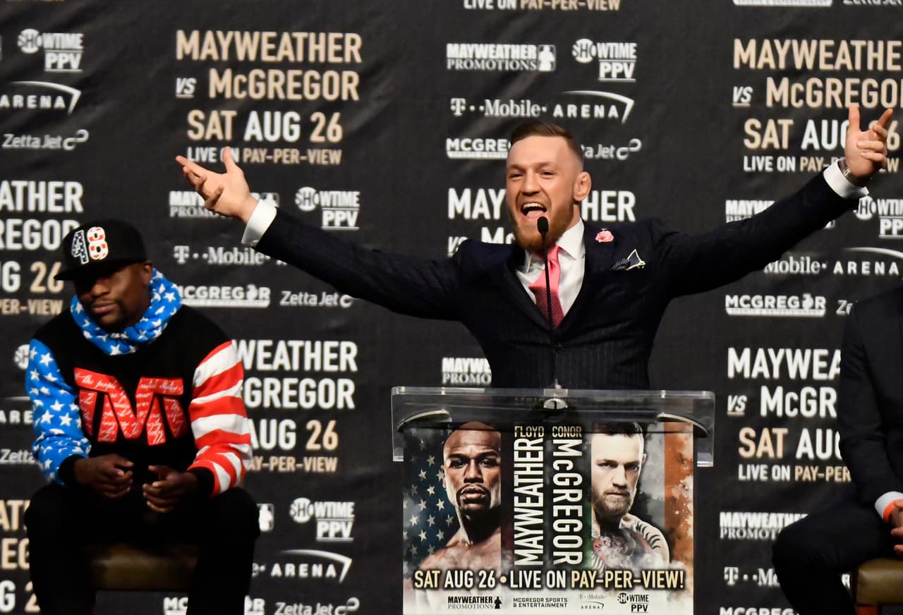Floyd Mayweather Jr. (L) looks on as UFC fighter Conor McGregor speaks about their upcoming fight during a press call at the Staples Center in Los Angeles, California on July 11, 2017. The two will fight August 26th in Las Vegas, Nevada. / AFP PHOTO / Gene Blevins (Photo credit should read GENE BLEVINS/AFP/Getty Images)
