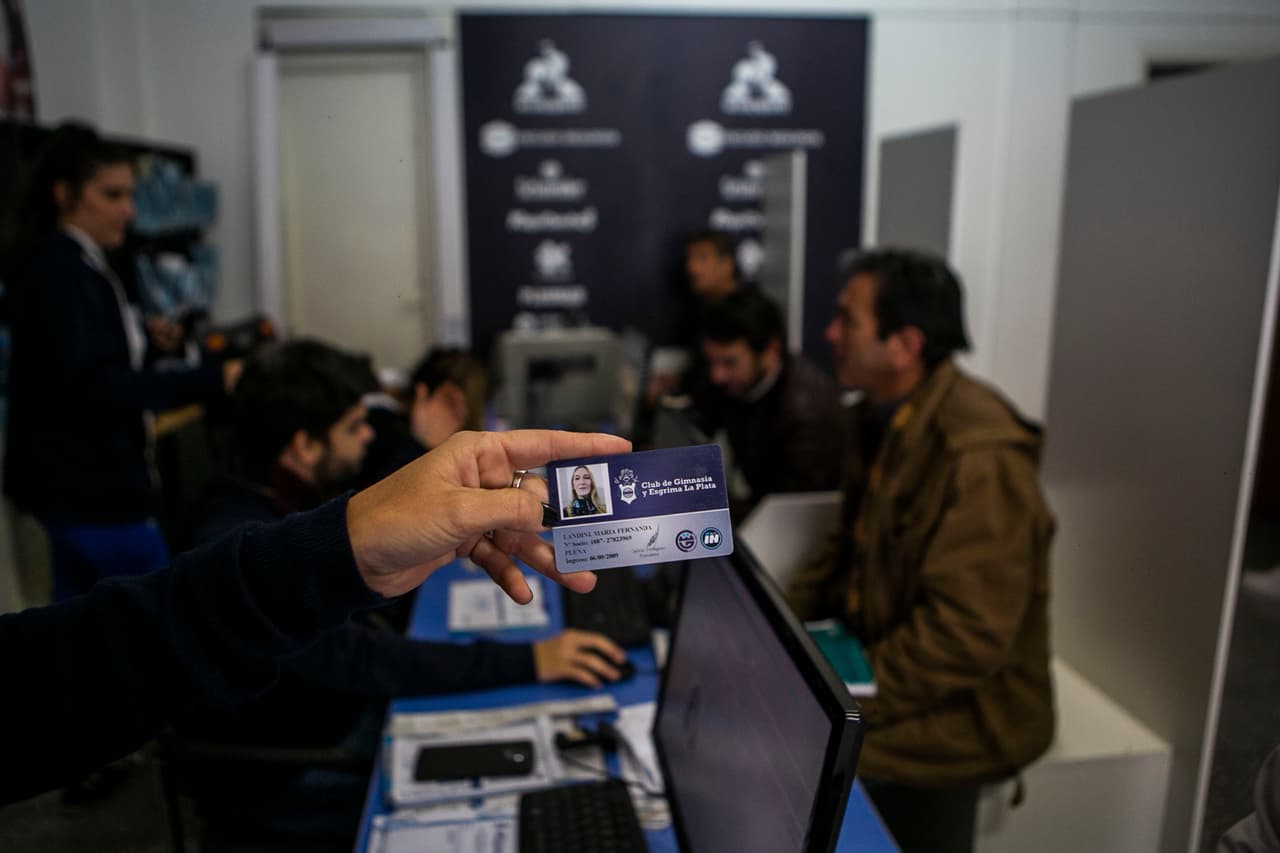 Una mujer mostrando su credencial como miembro del equipo.