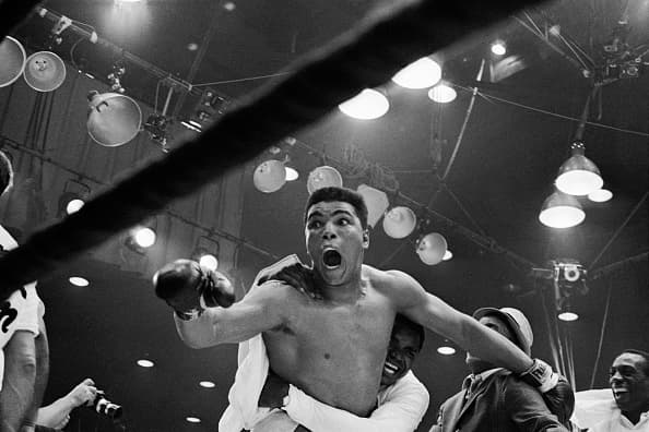 (Original Caption) "I'm the champ!" screams Cassius Clay as his handlers hug him joyfully after he defeated Sonny Liston for the heavyweight boxing title. Clay was credited with a 7th round TKO when Liston was unable to answer the bell because of a shoulder injury suffered in the first round.