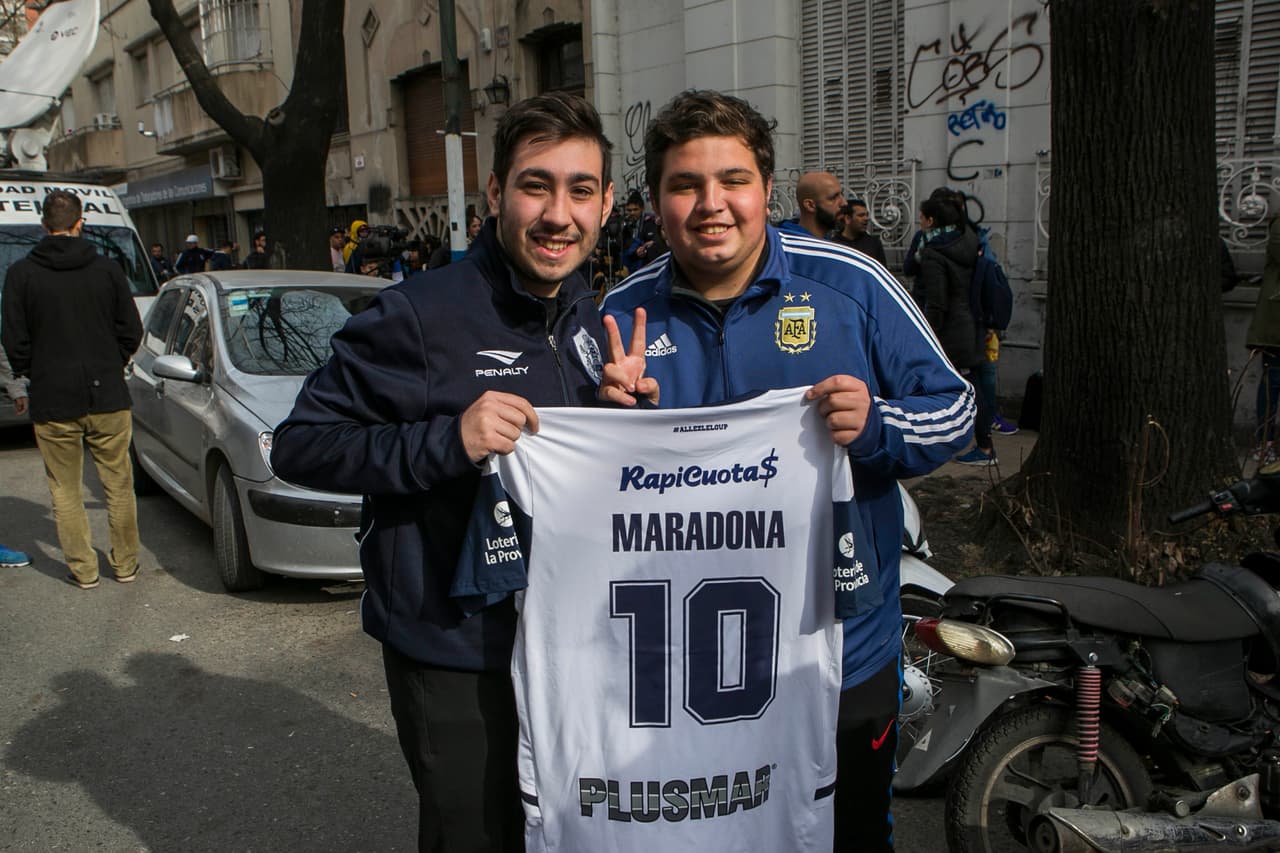 Los fanáticos posan con la playera del equipo.