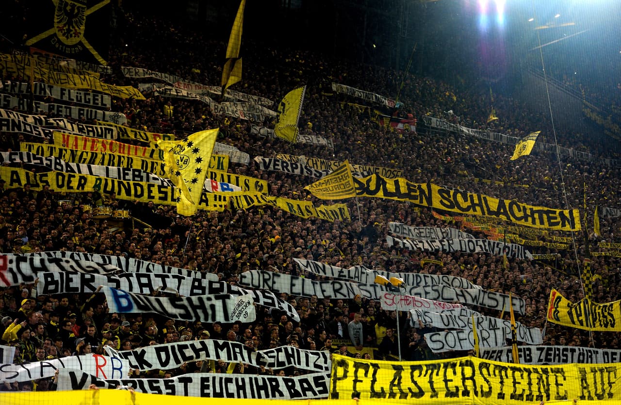 This picture taken on February 4, 2017 shows supporters of Dortmund displaying banners prior to the German First division Bundesliga football match between Borussia Dortmund and RB Leipzig, in Dortmund, western Germany. / AFP / SASCHA SCHUERMANN / RESTRICTIONS: DURING MATCH TIME: DFL RULES TO LIMIT THE ONLINE USAGE TO 15 PICTURES PER MATCH AND FORBID IMAGE SEQUENCES TO SIMULATE VIDEO. == RESTRICTED TO EDITORIAL USE == FOR FURTHER QUERIES PLEASE CONTACT DFL DIRECTLY AT + 49 69 650050 (Photo credit should read SASCHA SCHUERMANN/AFP/Getty Images)