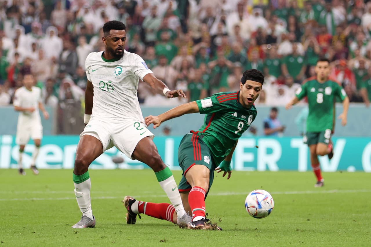 LUSAIL CITY, QATAR - NOVEMBER 30: Raul Jimenez of Mexico is fouled by Riyadh Sharahili of Saudi Arabia during the FIFA World Cup Qatar 2022 Group C match between Saudi Arabia and Mexico at Lusail Stadium on November 30, 2022 in Lusail City, Qatar. (Photo by Michael Steele/Getty Images)