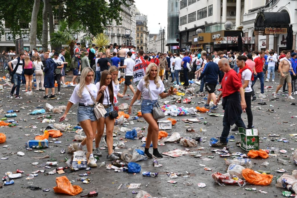 La gente camina sobre la basura.