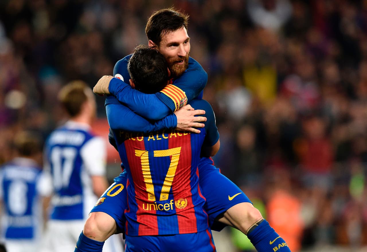 Barcelona's forward Paco Alcacer (bottom) celebrates a goal with Barcelona's Argentinian forward Lionel Messi during the Spanish league football match FC Barcelona vs Real Sociedad at the Camp Nou stadium in Barcelona on April 15, 2017. / AFP PHOTO / LLUIS GENE (Photo credit should read LLUIS GENE/AFP/Getty Images)