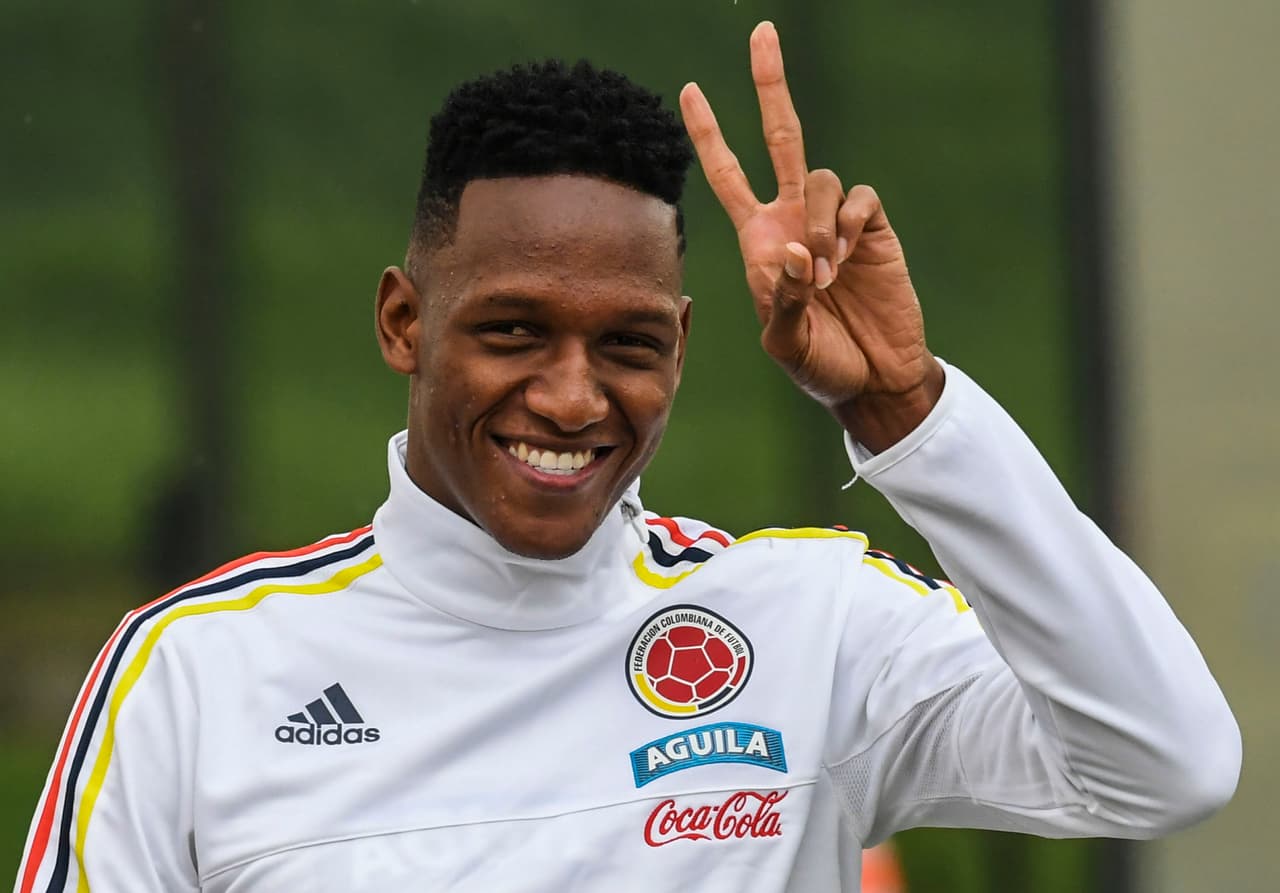 Colombia's defender Yerry Mina makes the "v" sign to the journalists before a training session at the Colombian football Federation in Bogota on March 25 2017 ahead of their FIFA World Cup South American qualifier football match against Ecuador. / AFP PHOTO / Luis Acosta (Photo credit should read LUIS ACOSTA/AFP/Getty Images)