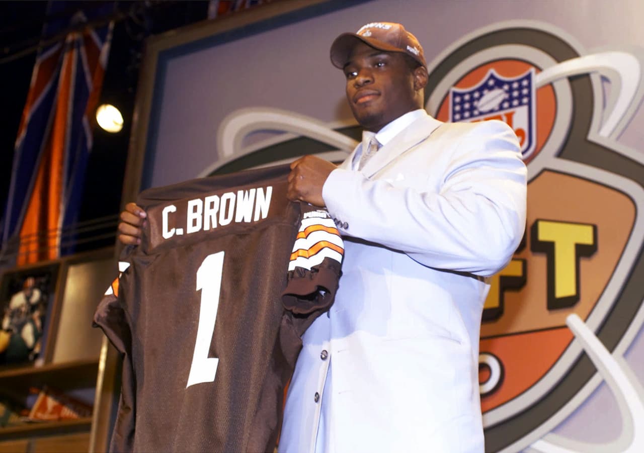 2000 — COURTNEY BROWN
<b>Cleveland Browns</b> | DE Penn State
<br>El ala defensiva Courtney Brown de Penn State, sostiene una camiseta de los Cleveland Browns luego de ser seleccionado por los Browns como la selección N° 1 del draft de la NFL el sábado 15 de abril de 2000 en Nueva York. (AP Foto / Ed Betz)