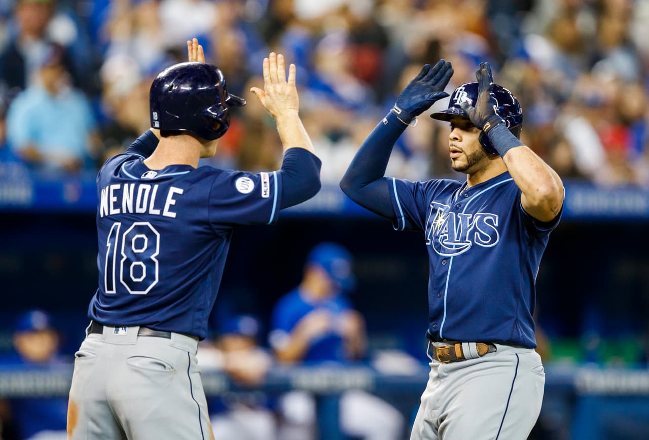 Tommy Pham con el #29 de los Tampa Bay Rays celebra con Joey Wendle #18 en el partido contra los Toronto Blue Jays
