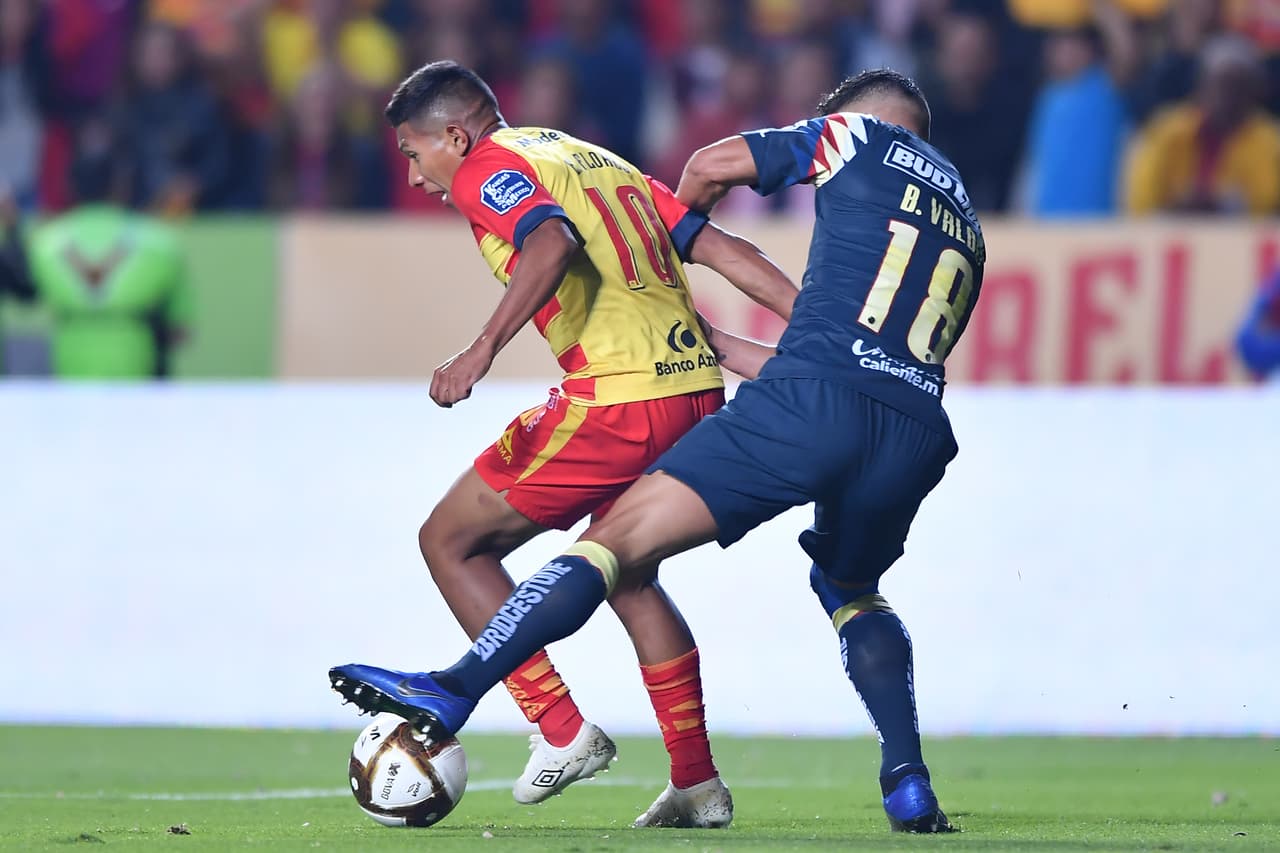 Édison Flores y Bruno Valdez pelean por el esférico en el medio campo.