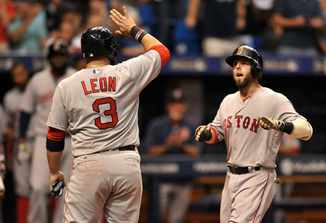 Boston Red Sox's Sandy Leon (3) waits at the plate to celebrate with Dustin Pedroia, right, after scoring on Pedroia's grand slam off Tampa Bay Rays reliever Danny Farquhar during the seventh inning of a baseball game Saturday, Sept. 24, 2016, in St. Petersburg, Fla. (AP Photo/Steve Nesius)