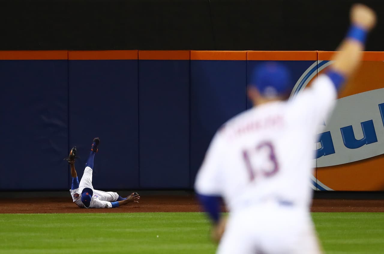 Curtis Granderson de New York Mets realiza una espectacular atrapada contra los San Francisco Giants durante su partido por la Wild Card en la Liga Nacional.