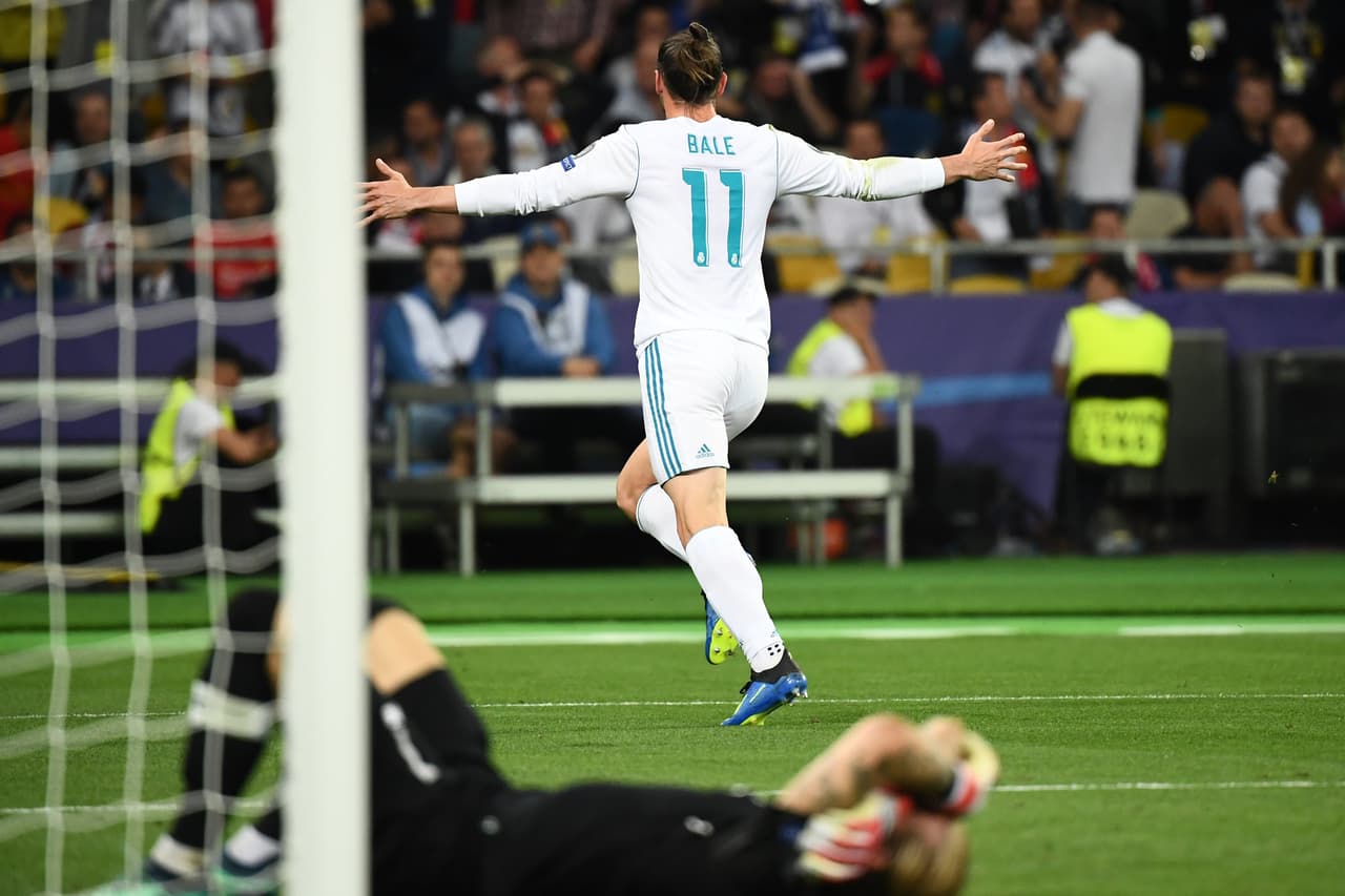 Real Madrid's Welsh forward Gareth Bale (up) celebrates after scoring his team's third goal as Liverpool's German goalkeeper Loris Karius (down) reacts during the UEFA Champions League final football match between Liverpool and Real Madrid at the Olympic Stadium in Kiev, Ukraine, on May 26, 2018. (Photo by FRANCK FIFE / AFP) (Photo credit should read FRANCK FIFE/AFP/Getty Images)