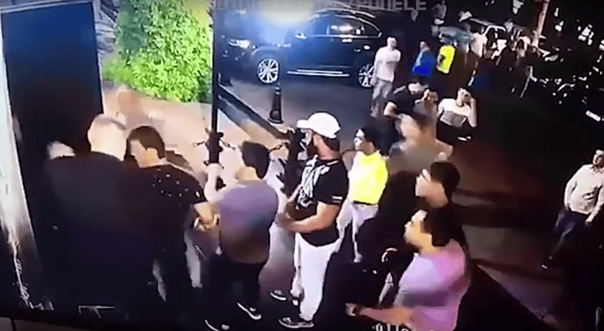 El hombre de playera gris empuja al luchador y lo deja fuera del cuadro de las cámaras.