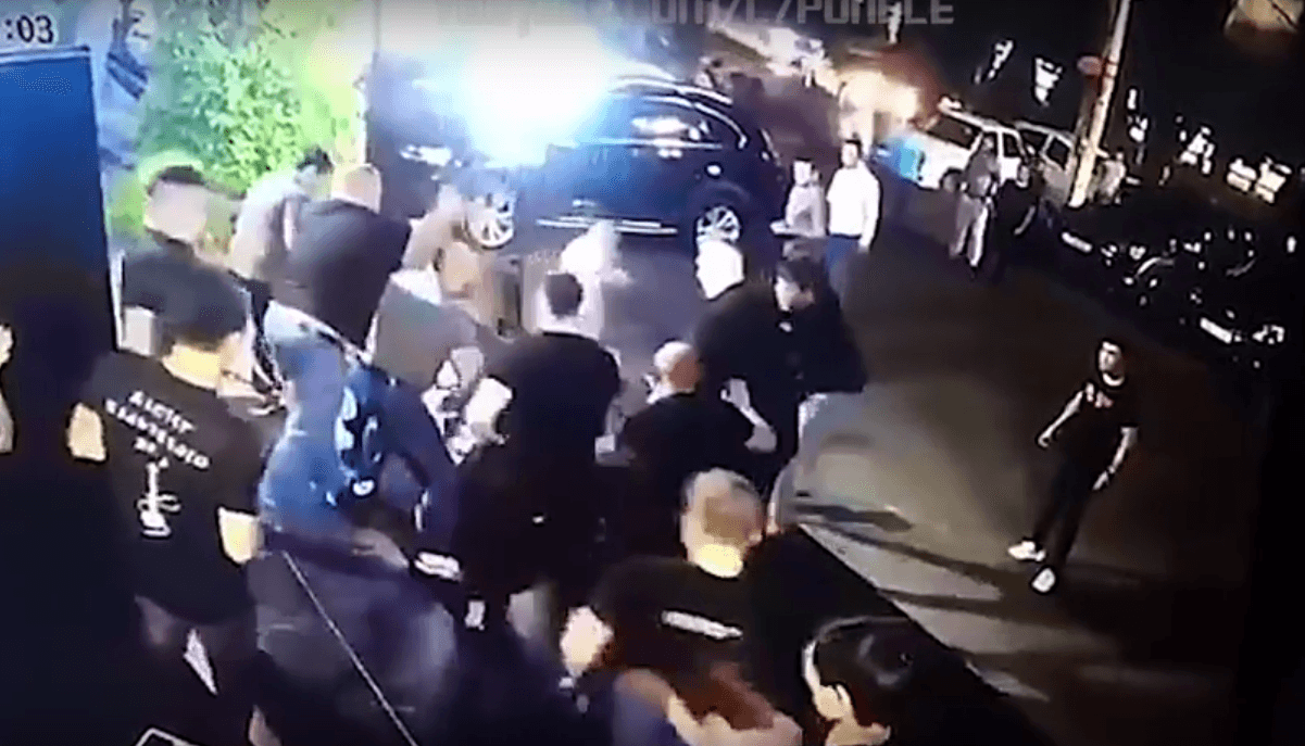 La agresión contra el luchador inmovilizado desata un intento de reacción de los acompañantes pero los guardias tienen ventaja de posición para evitar que se acerquen.